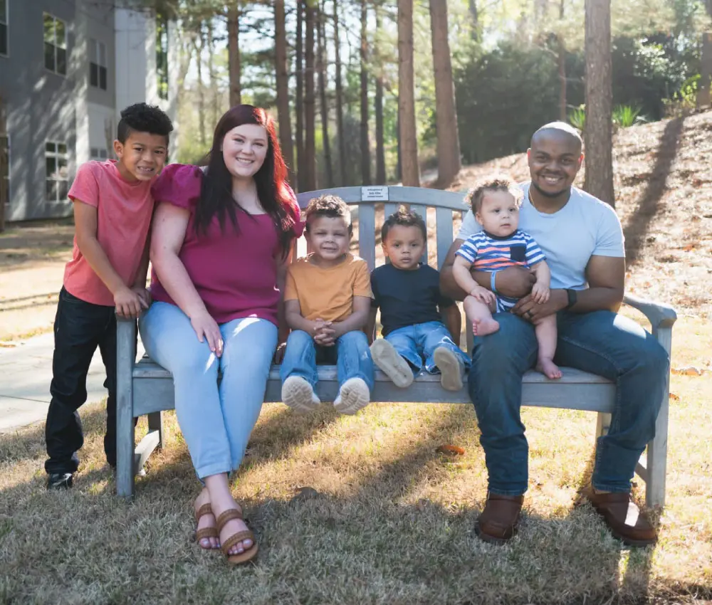 family sitting on bench outside