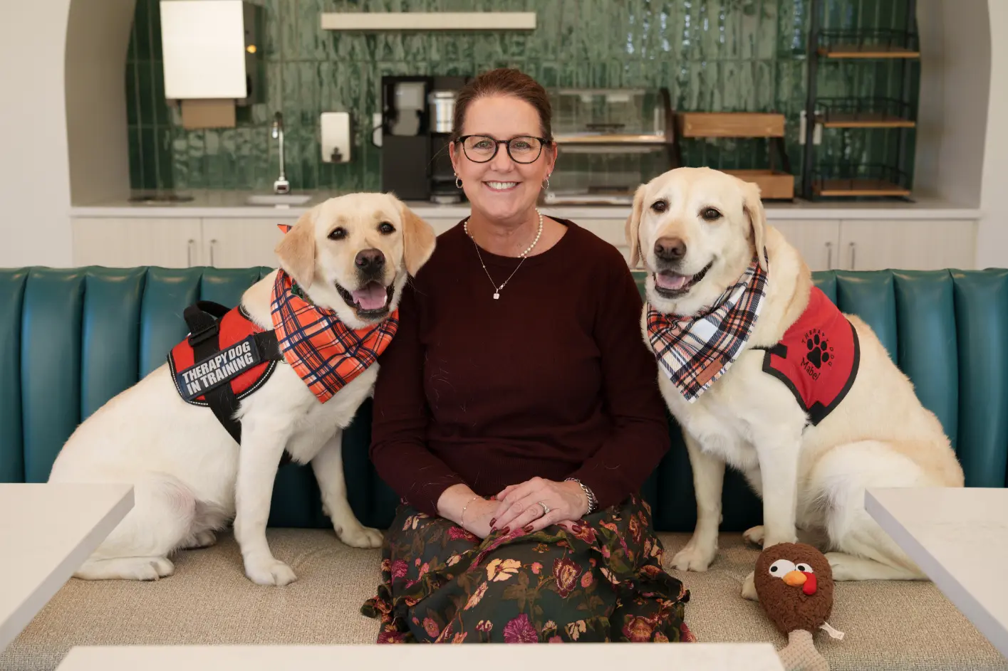 woman sitting on bench with two dogs