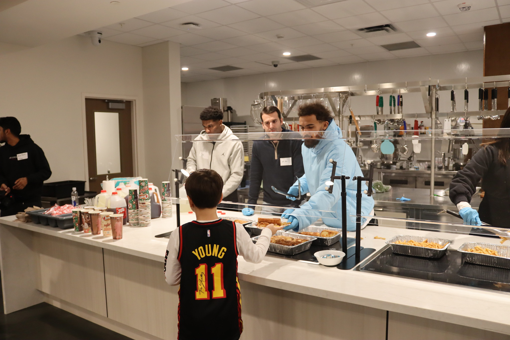 man handing boy food in kitchen