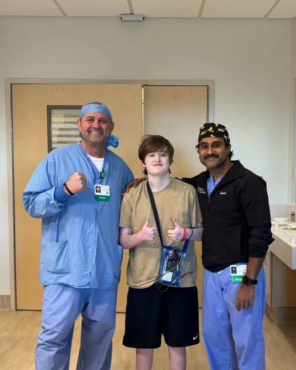 boy standing with two doctors in hospital
