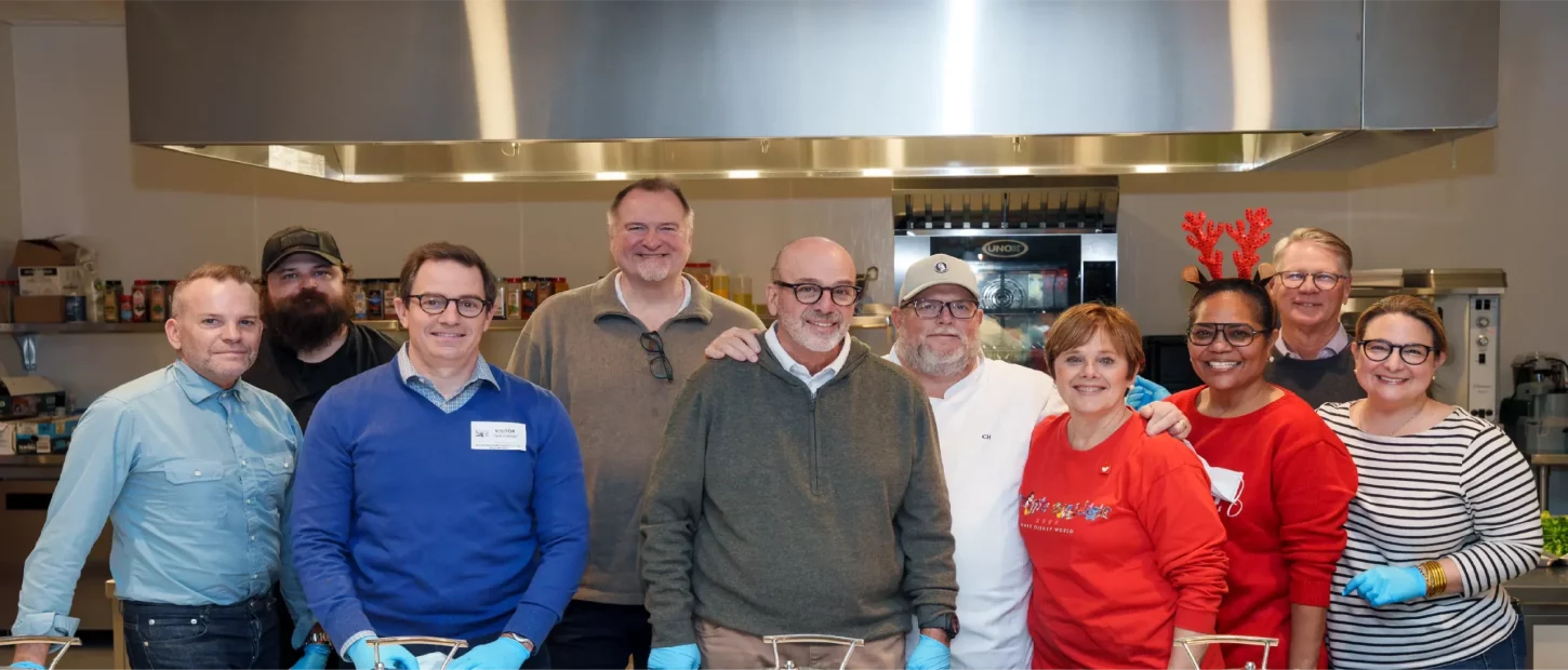 group of people standing in kitchen
