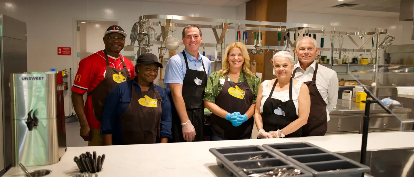 group of people standing in a kitchen