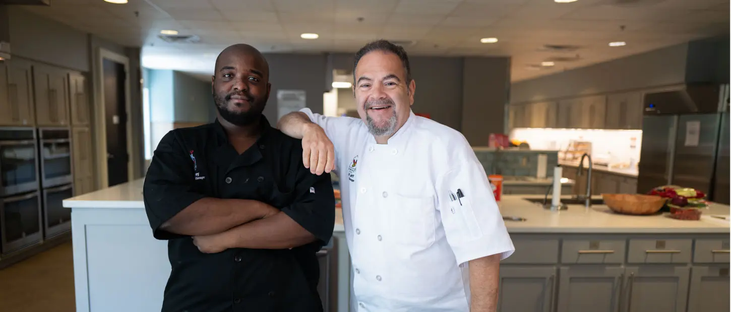 two men standing in a kitchen smiling