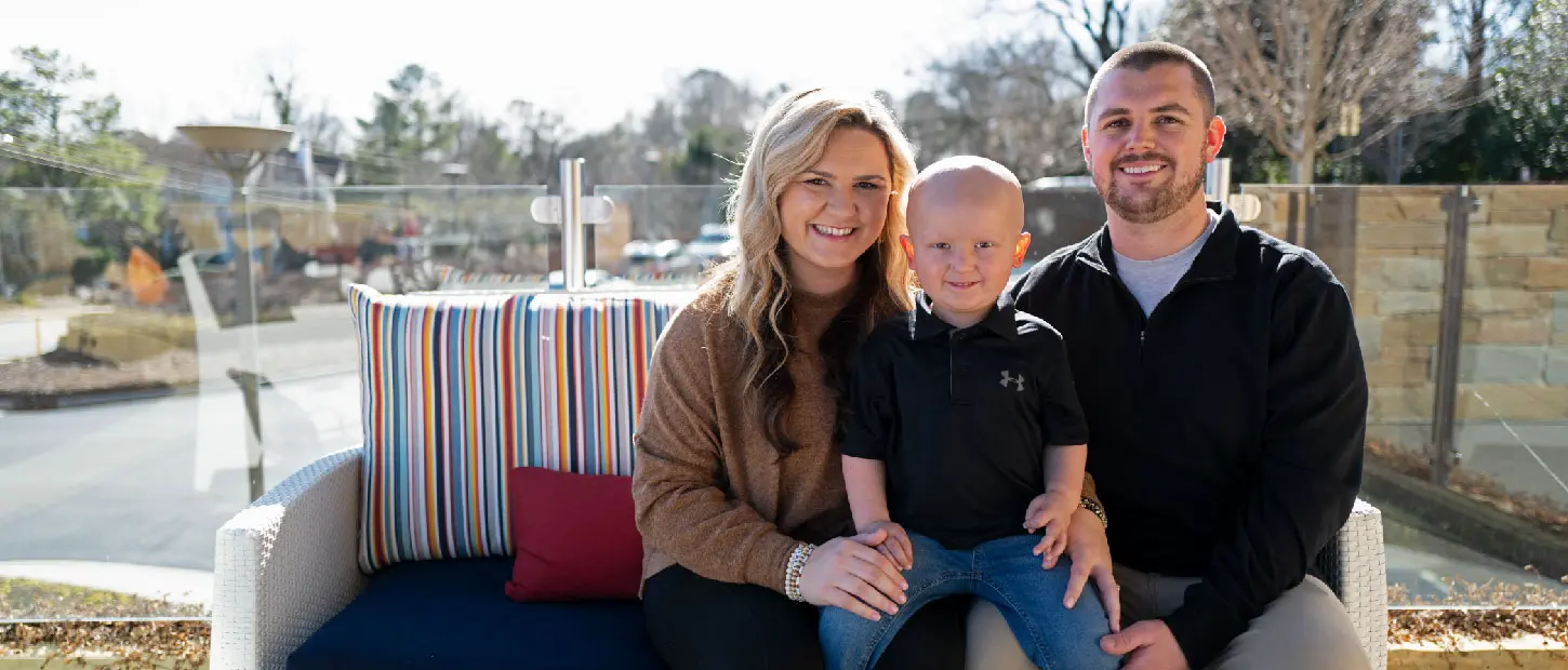 man woman and boy sitting on a bench smiling