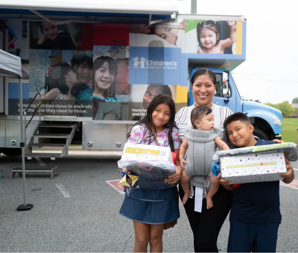 mother with three young children receiving care from care mobile
