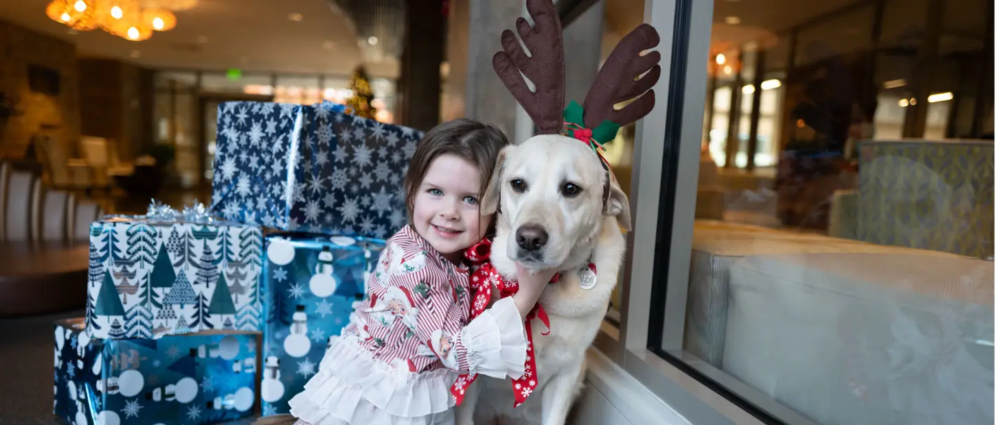 girl hugging dog with antlers on