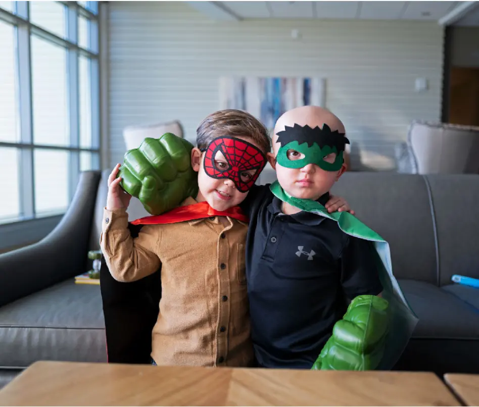 two boys in costumes hugging