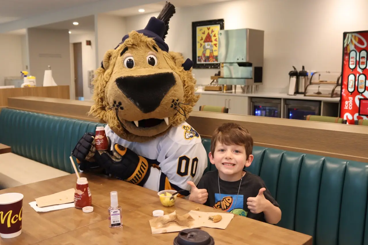 lion mascot and boy in kitchen