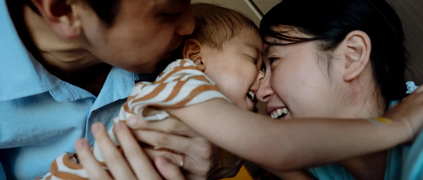 woman and man holding girl smiling