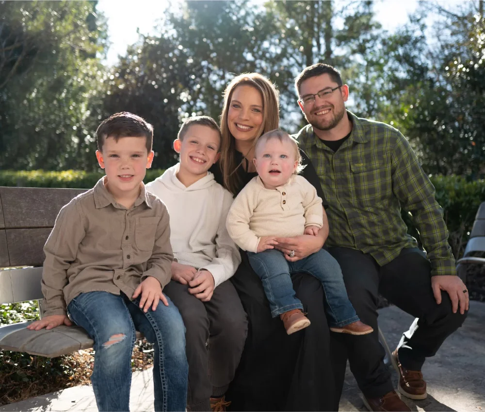 family sitting on bench outside