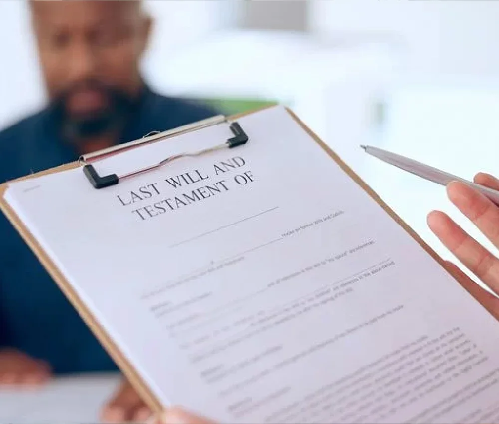 person holding clipboard with will and testament document