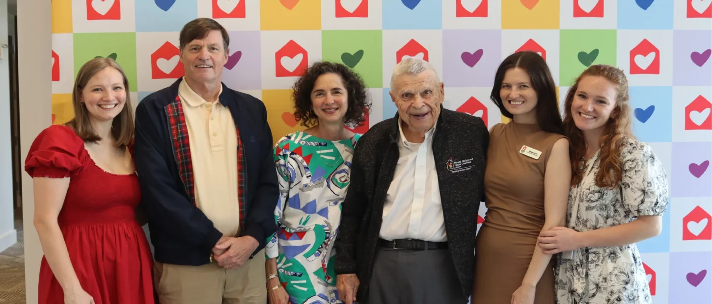 Group of people standing in front of a colorful background