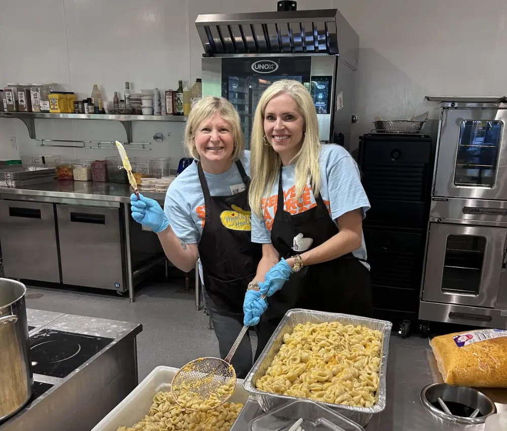 two woman in a kitchen smiling