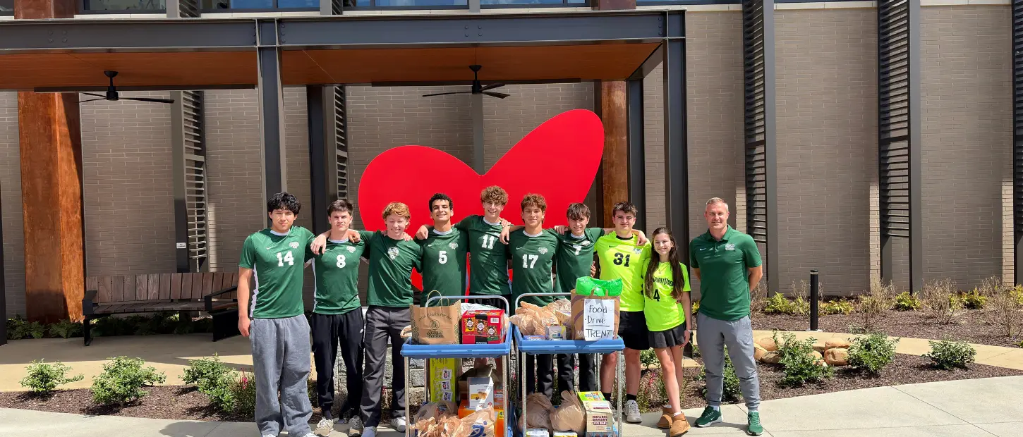 group of people standing in front of a heart scultpture