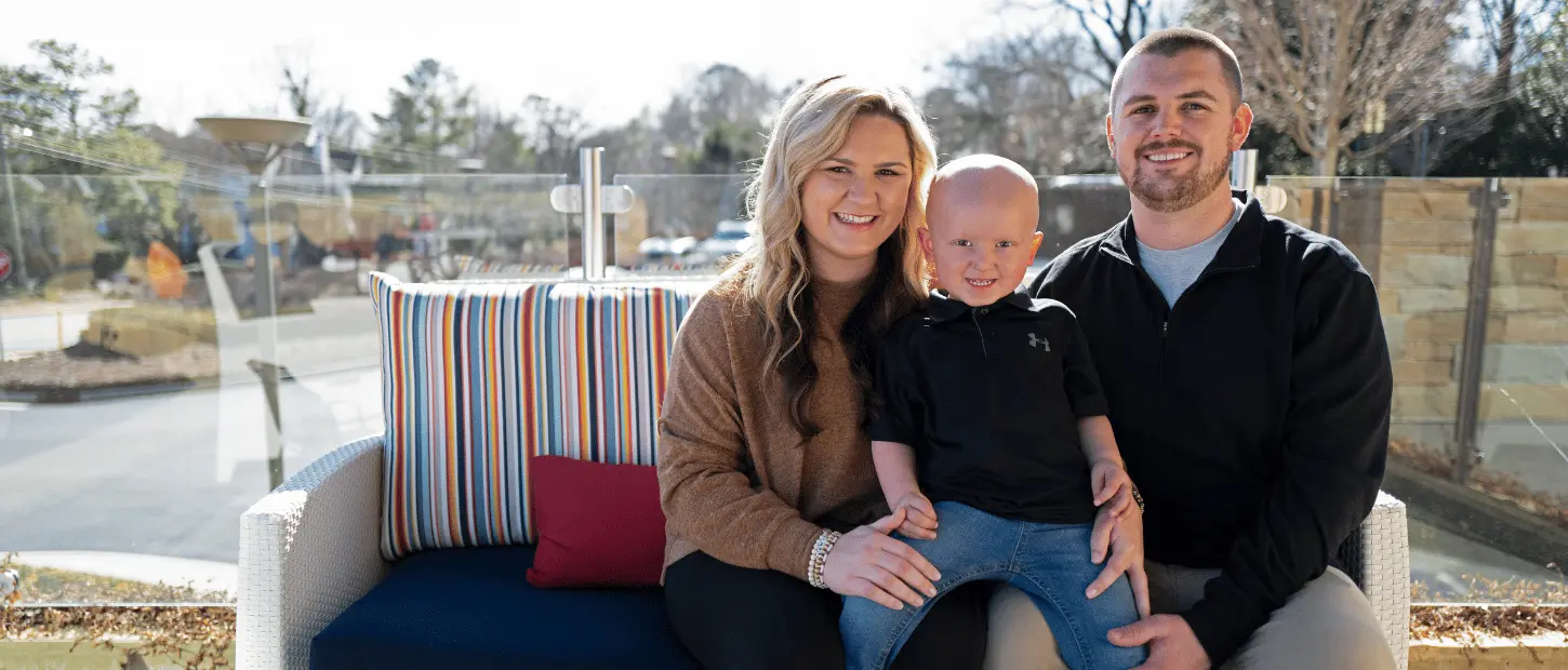 man woman and boy sitting on a bench smiling