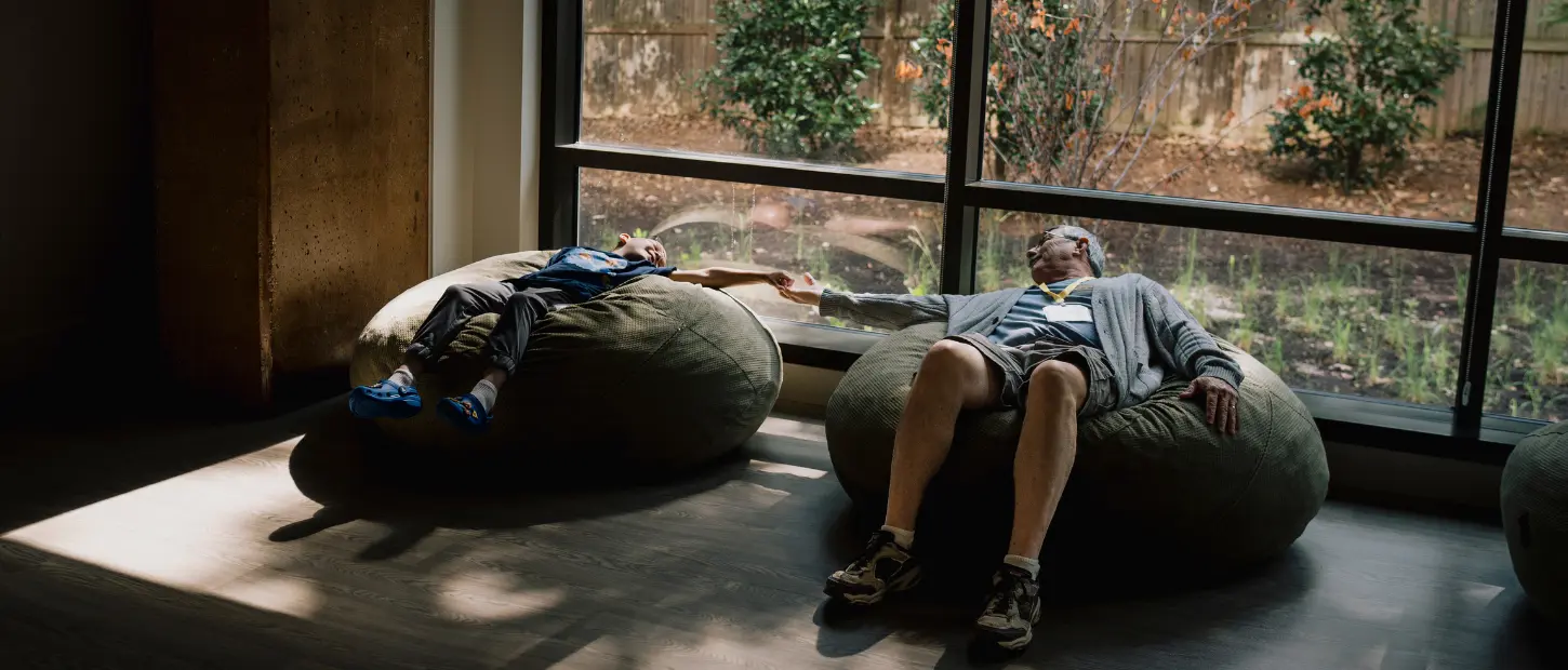 man and boy holding hands laying down