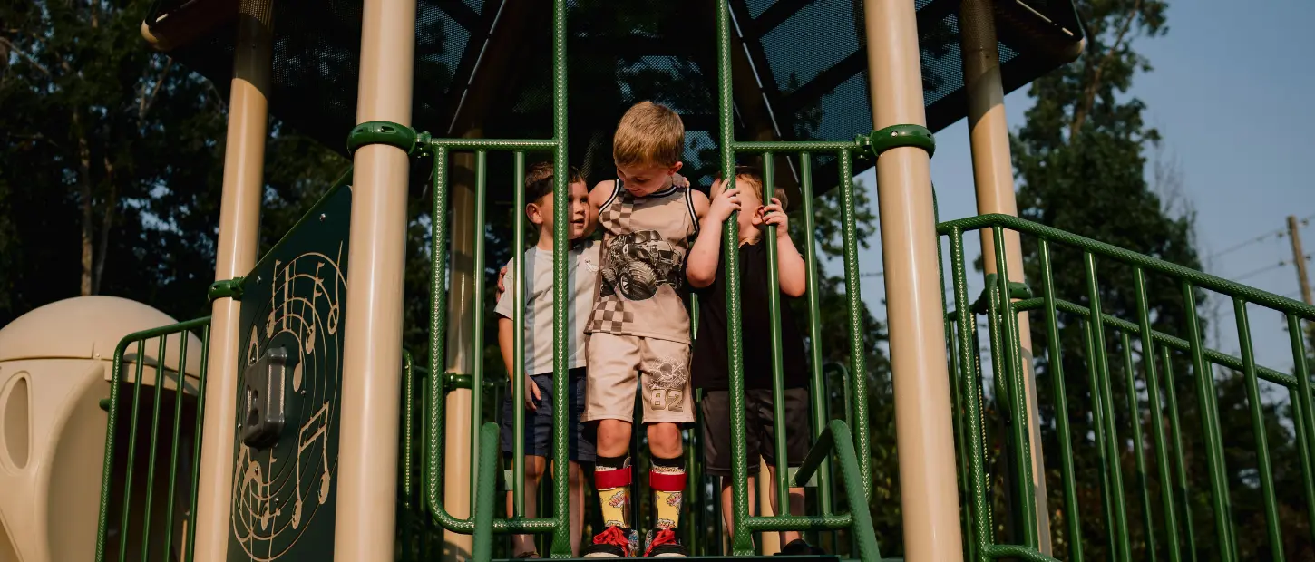 three boys standing on a playground