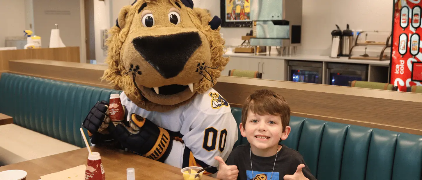 lion mascot and boy in kitchen