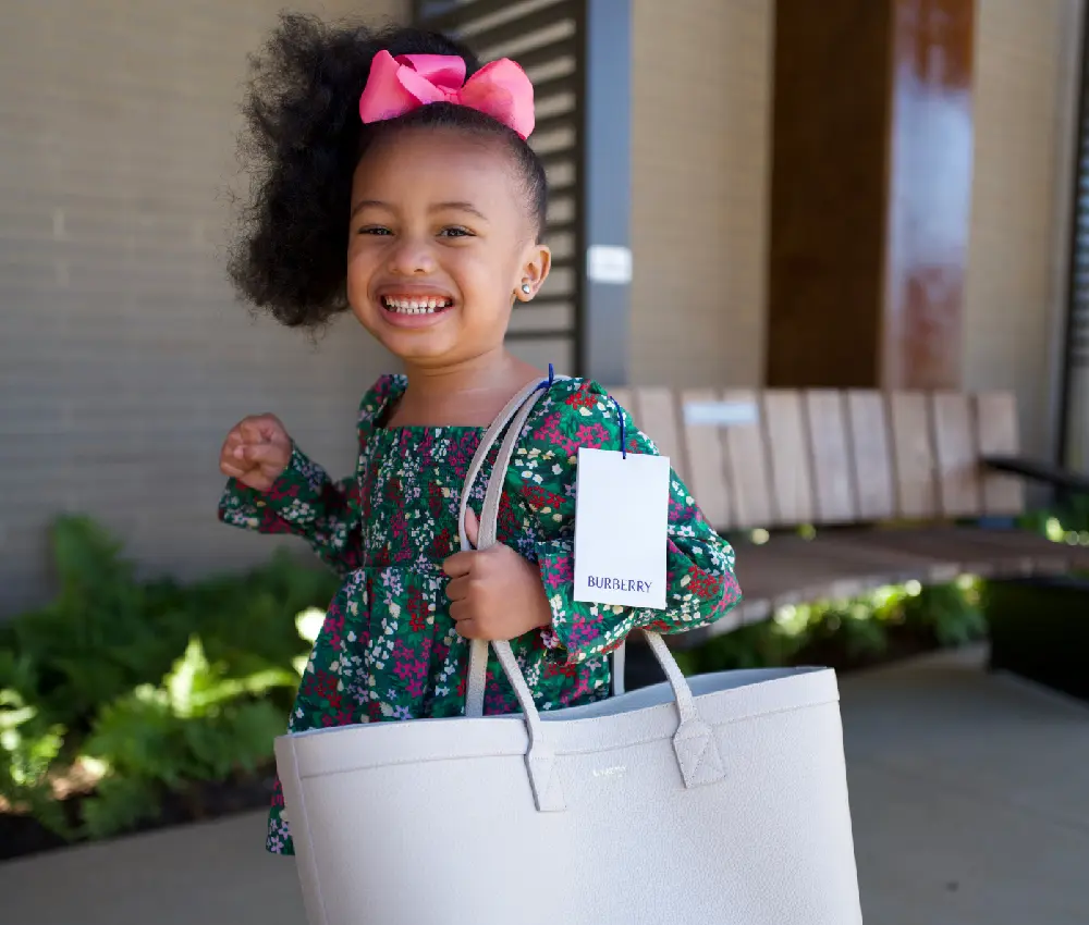 girl smiling holding purse